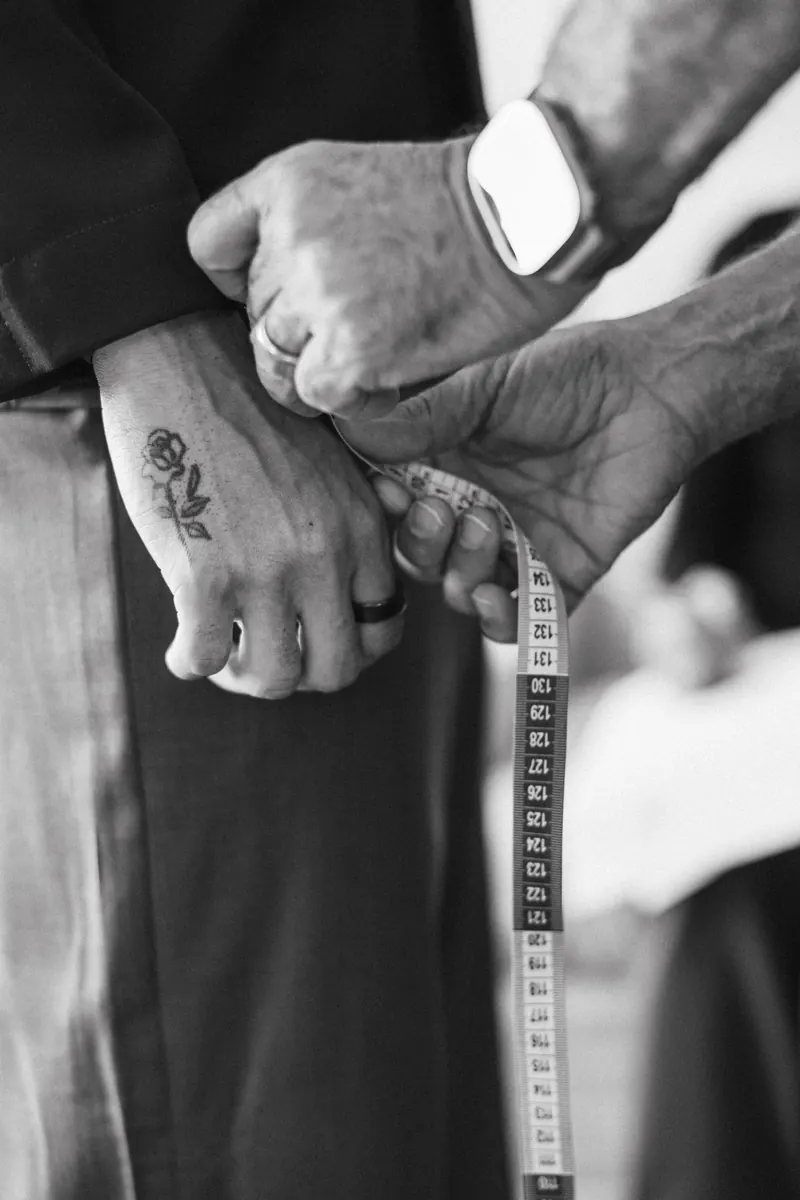Black and white close up of hands and a measuring tape