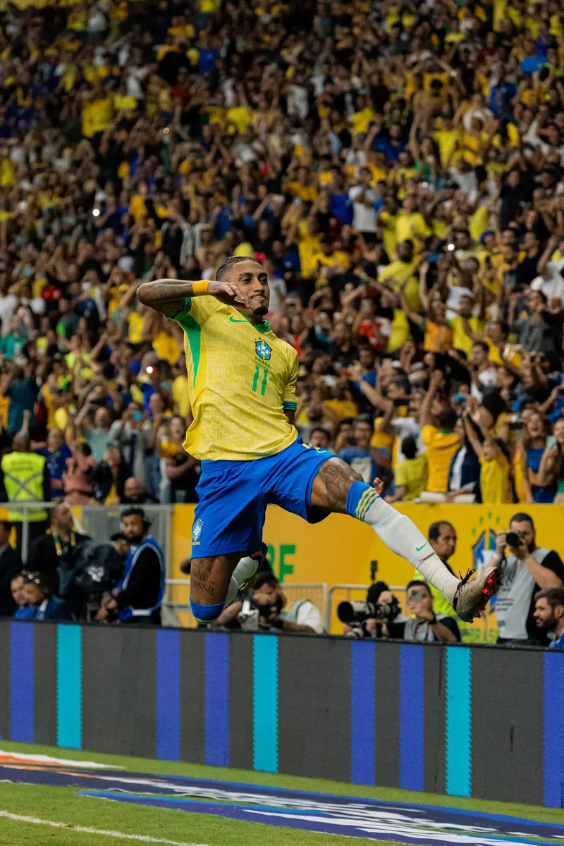 Brazil number 11 leaping in celebration in front of the stands