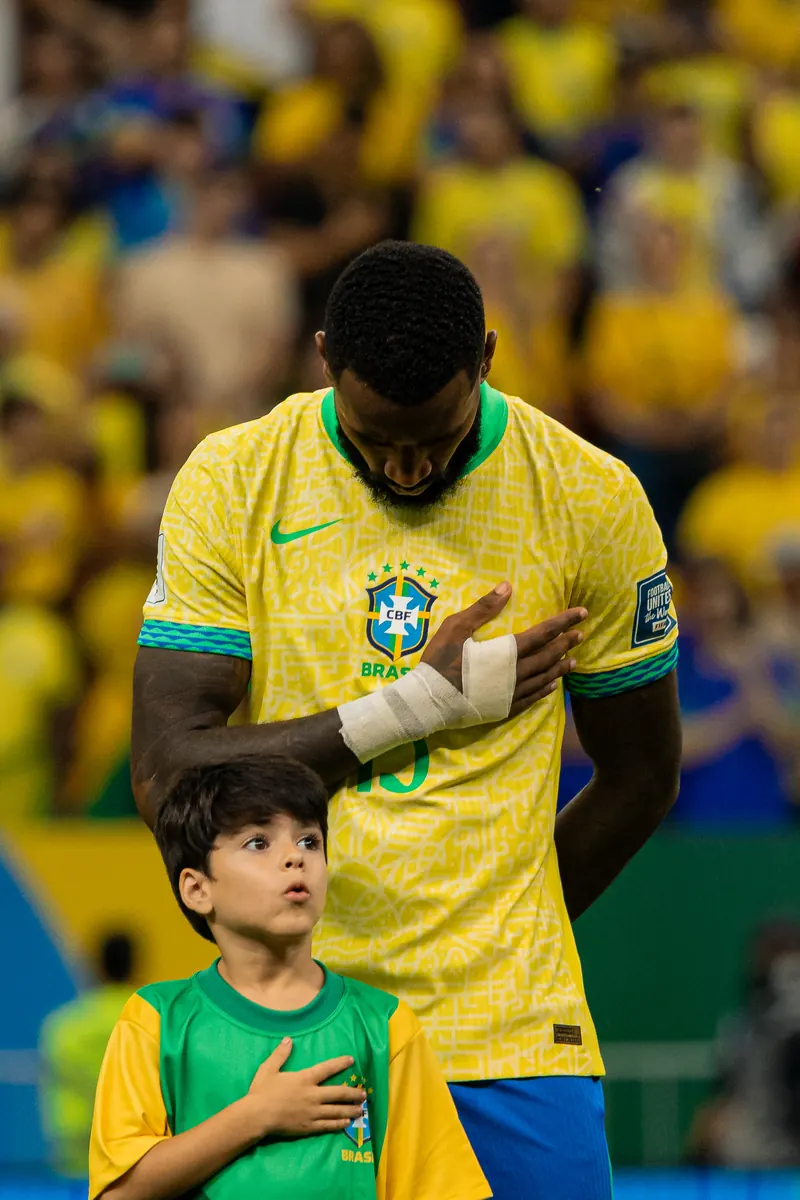 Brazil player with a young mascot during the national anthem