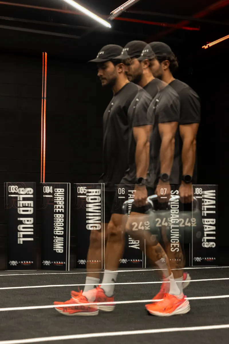 Multiple exposure of an athlete carrying kettlebells in Puma shoes