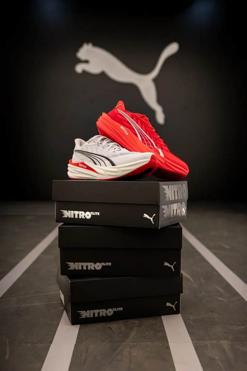 Red Puma Nitro shoe on a stack of boxes under the Puma logo